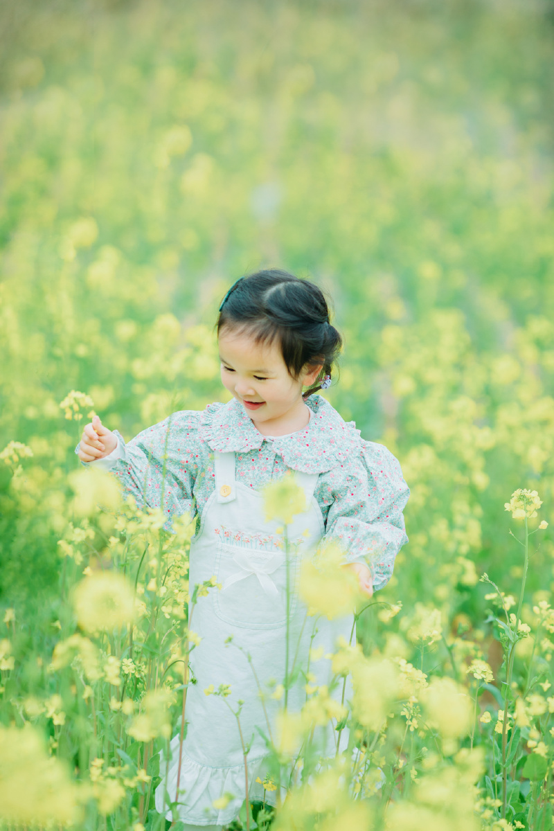 油菜花开跑向春天的小女孩