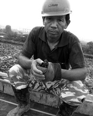 拍摄于2007年5月25日，湖北省武汉市汉阳区，汉蔡高速公路1标。一名年仅稍大工人，工作一段时间后，临时休息，看着我相机的眼神有些无奈。