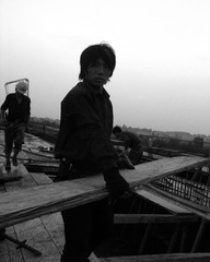 拍摄于2007年5月25日，湖北省武汉市汉阳区，汉蔡高速公路1标。一名工人搬着拆除出来的木板，为下道工序施工做准备。