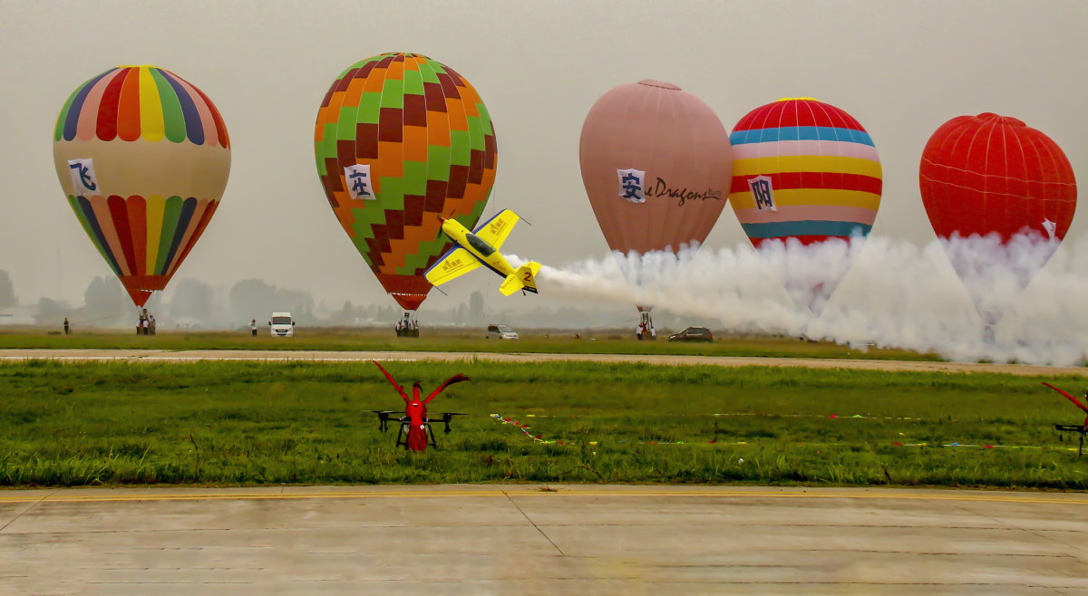 航空节上,表演的飞机从热气球前飞过 - 琴瑟和谐 - 图虫