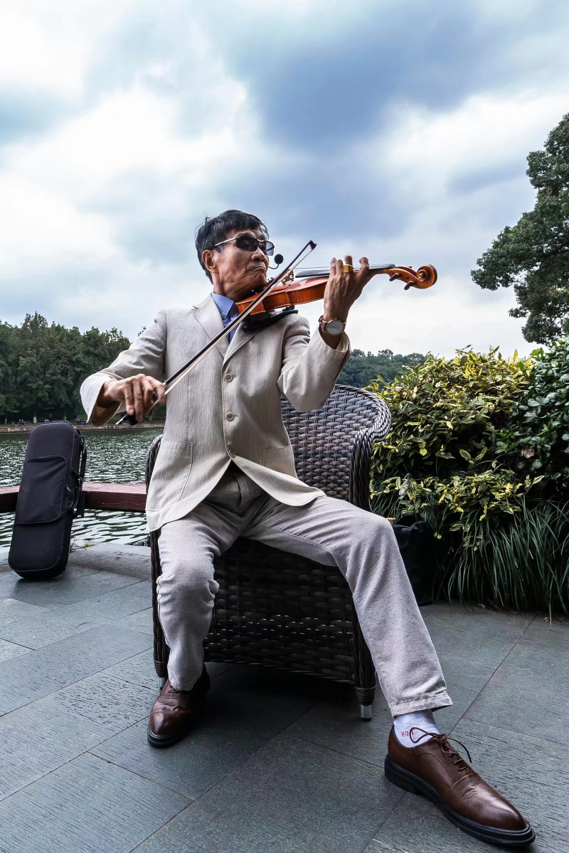 西湖边拉小提琴的老人