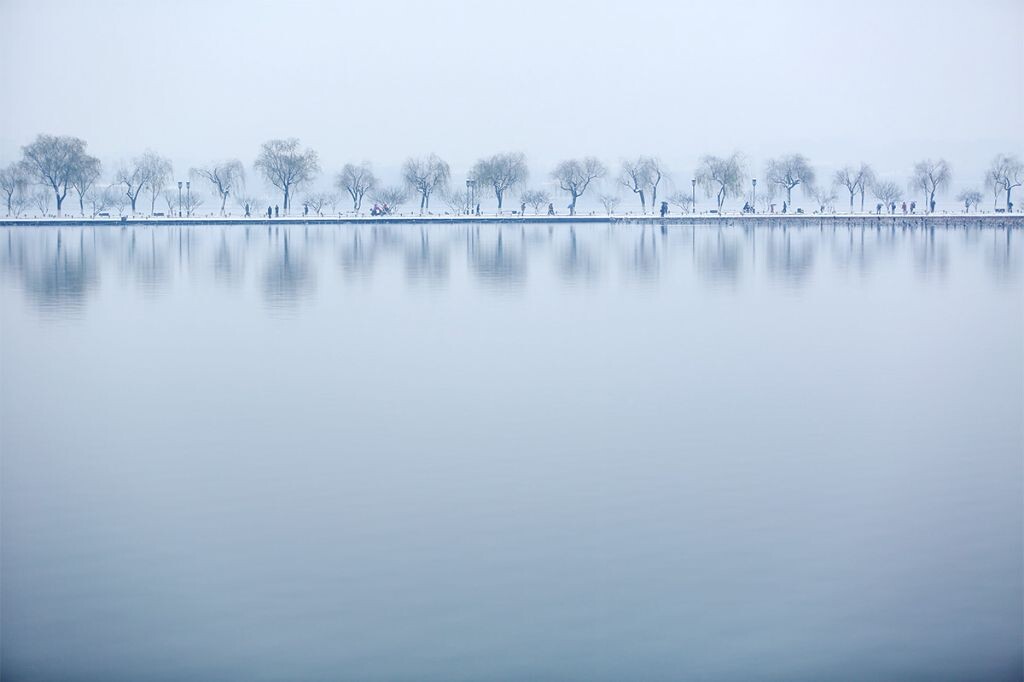 一夜大雪，将杭州西湖渲染得白静无暇。横卧湖上的白堤素净优雅。