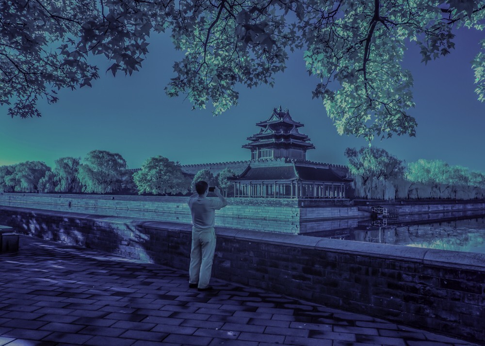 现如今故宫角楼已成为北京一景，不论春夏秋冬这里都会聚集大批的观光客和摄影师，难得在那个盛夏的午后，我用红外相机记录下了这位北京老人用手机留住了身边的美景