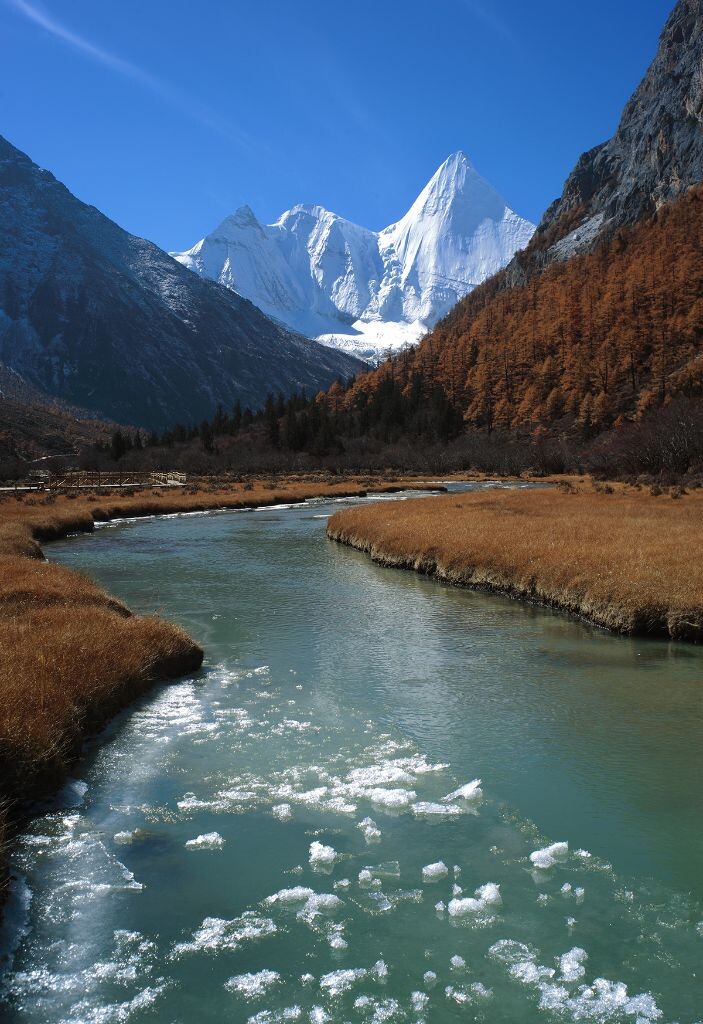 雪山冰河<br />
在海拔4300多米的高原上，当别人或骑马或乘坐电瓶车代步的时候，我却扛着沉重的摄影器材步行10多公里来到央迈永神山脚下，我被眼前的景观所震撼……<br />
冰河融化，一缕缕云从山际飘过，一条优美的曲线在脚下延伸……<br />
于是，分别拍摄了远、中、近景3张照片，后期拼接已达到完美的景深。