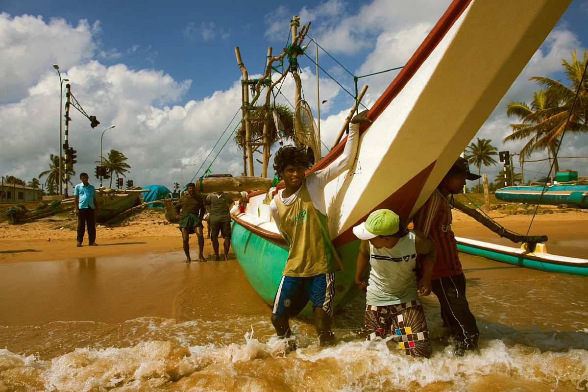渔民归港 br /> 午后,一群渔民捕鱼归来,正在推船入港