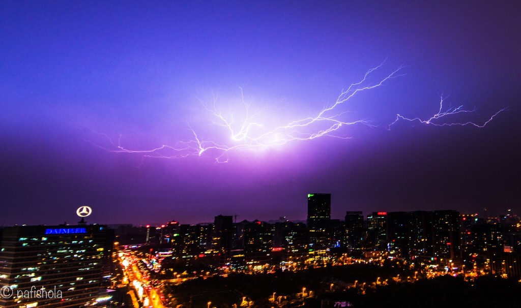 滂沱的雨，路上的人行色匆匆，突然一道闪电划过夜空，照亮了漆黑的夜。