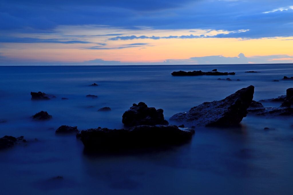 峰林雾海<br />
摄于北海涠洲岛，太阳渐渐西下，只留下余辉，天空渐渐变成深蓝，和静谧的大海相互呼应，礁石静静地呆在大海的摇篮，像个熟睡的婴儿探出头来，又像是峰林在云海中耸立。夜渐渐深了，世界渐渐地睡了……