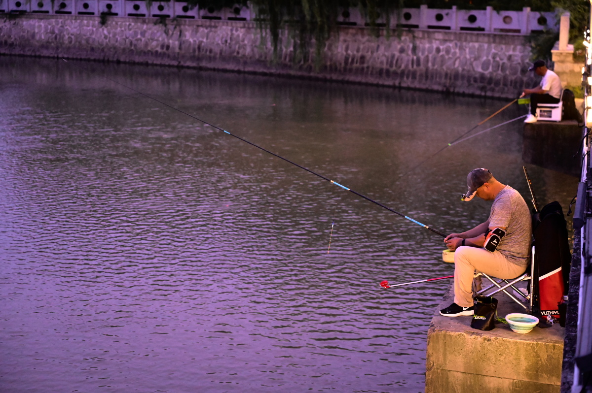 傍晚桥墩上的钓鱼人