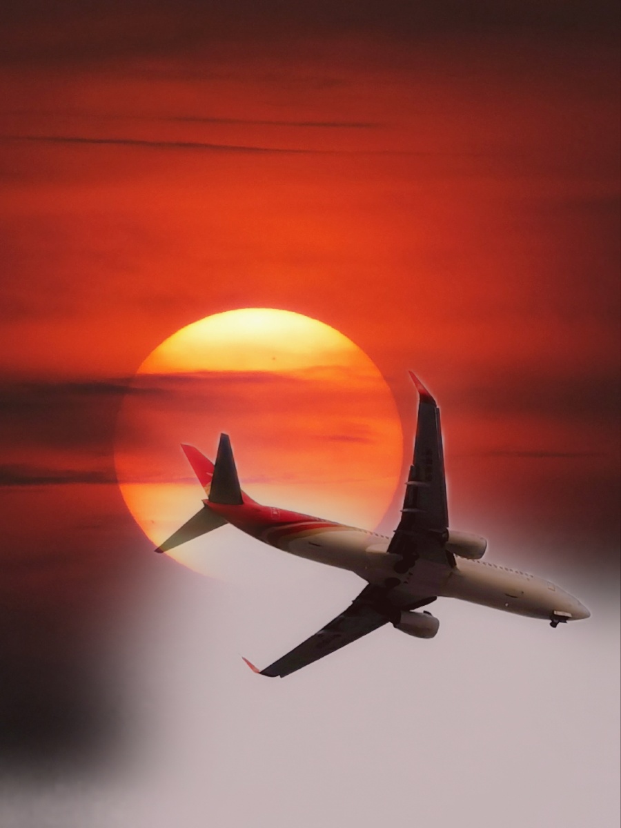 夕阳下一架飞机一架飞机从头顶飞过抓拍