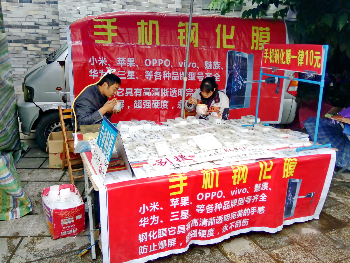 手机摄于雅安市雨城区在摊位上吃早饭的夫妇俩