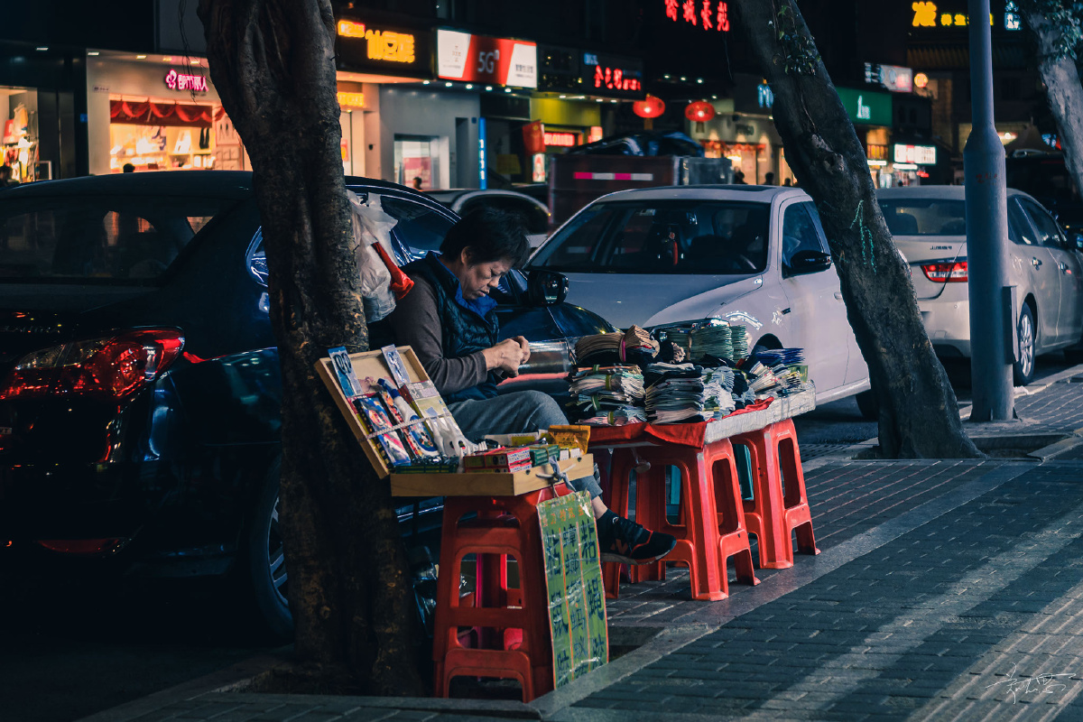 春节临近人流量比平时少了很多街边的小贩大多无所事事地坐着