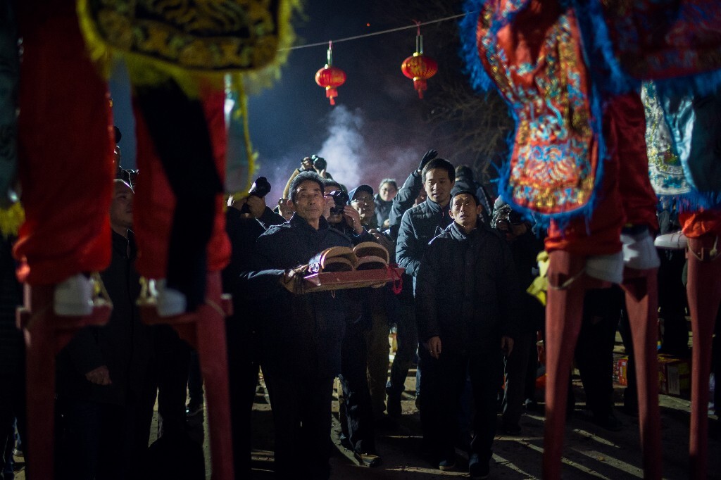 四名舞者皆身着战袍,扎竹马,排一字形横队面向神案站立。然后由执事长者替他们戴上面具,开始踩马,称踩“启圣马”。
