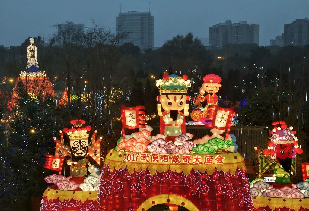 武侯祠不仅承载着历史三国文化,也是承载成都每年元宵庙会的重任。平日里,武侯祠基本上接待外地游客,但是大庙会期间,基本上很多老成都人都会重游武侯祠,重温记忆中庙会的热闹温度,回忆属于这个地方的历史。此刻的我,正站在大庙会对面的楼顶上,看着Q版的刘备、关羽、张飞和诸葛孔明,以及楼下熙熙攘攘的人群,仿佛置身于时空的隧道里,感受到的是1700多年的历史与现代文明的碰撞。