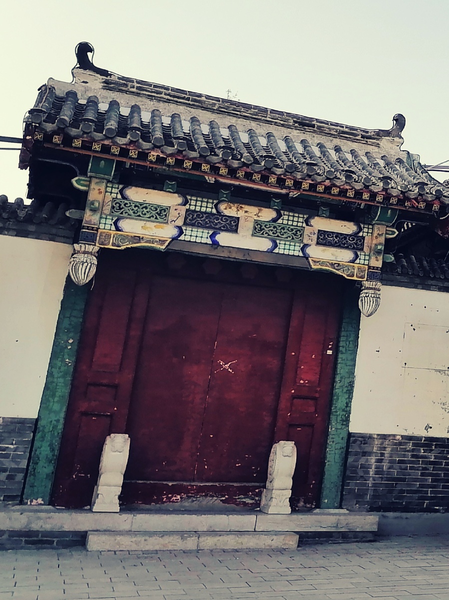 古建筑灰瓦白墙朱门闭晴空丽日少人迹