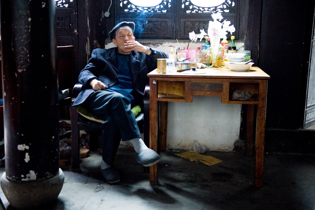 2011年3月13日,无锡荣巷,一位老人酒足饭饱后悠然自得地在抽烟。