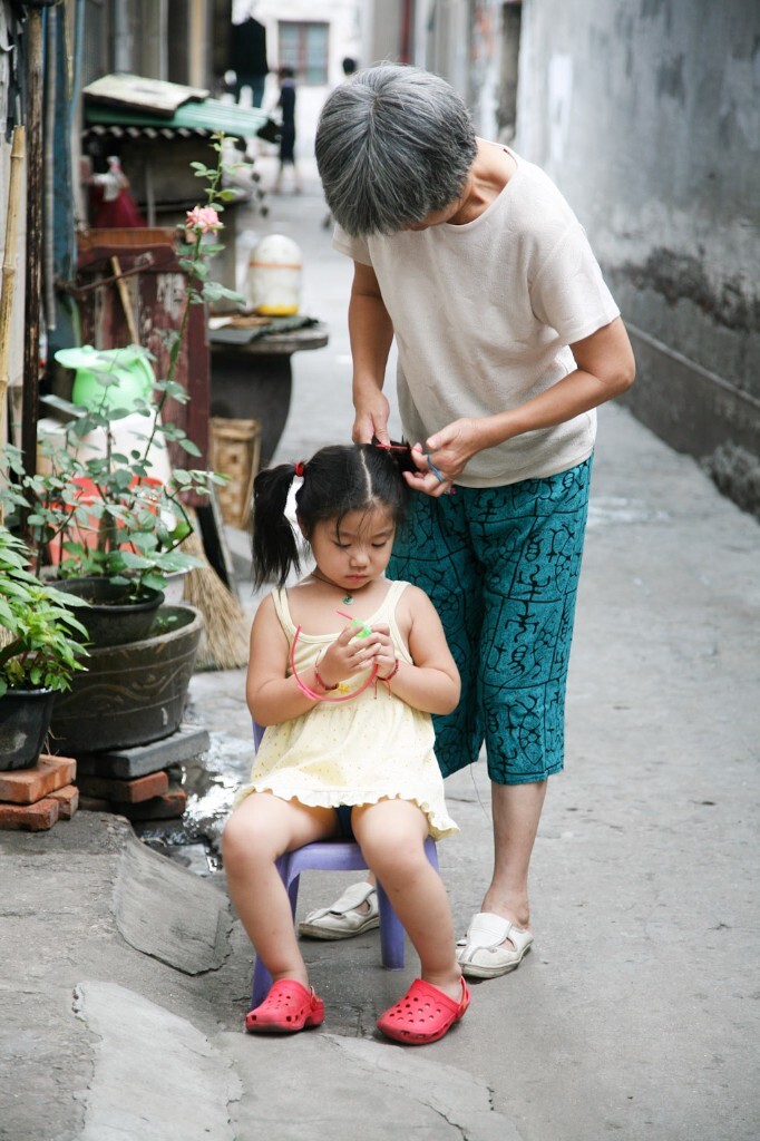 2009年7月15日,无锡丽新路四弄,奶奶给孙女扎头发。