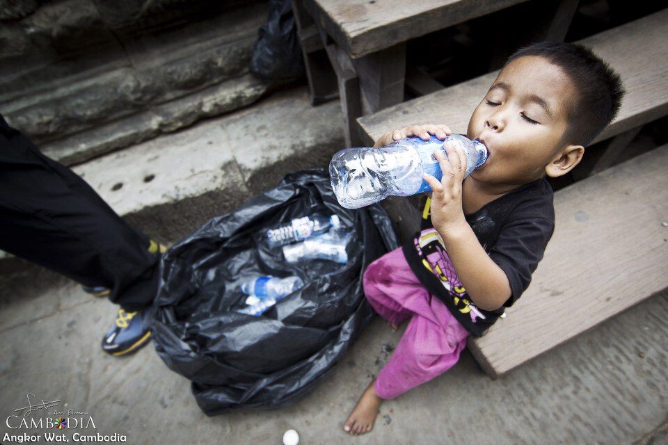 STE_7893-1<br />
在吴哥窟里一个拾荒的孩子，捡着游客丢掉的水瓶，喝一个个喝掉里面剩下的水。表情还很陶醉的样子....唉...