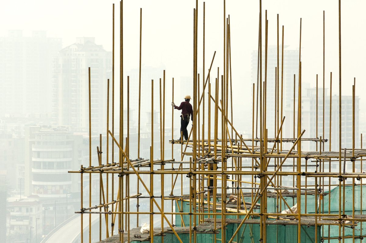 主体结构施工,搭棚工在钢管脚手架上高空作业.