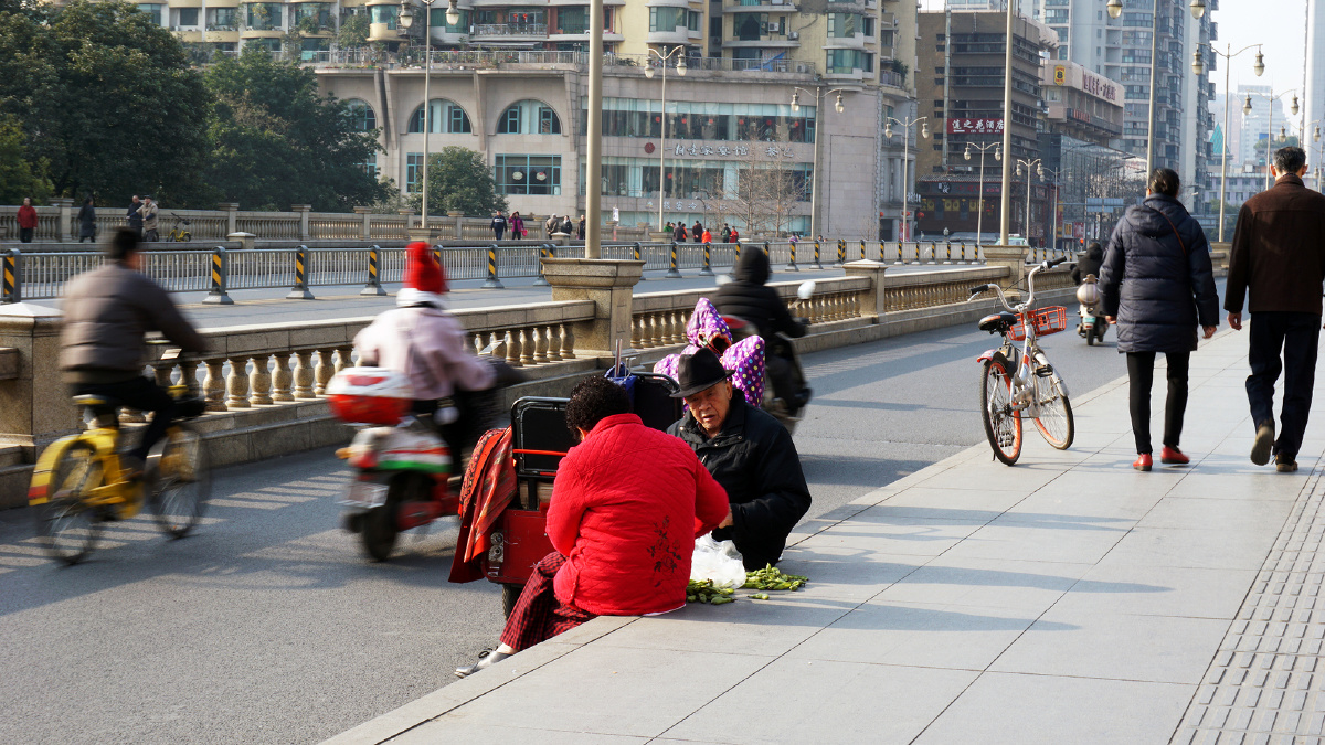 成都北门大桥,两老人走累了,坐桥上择菜!