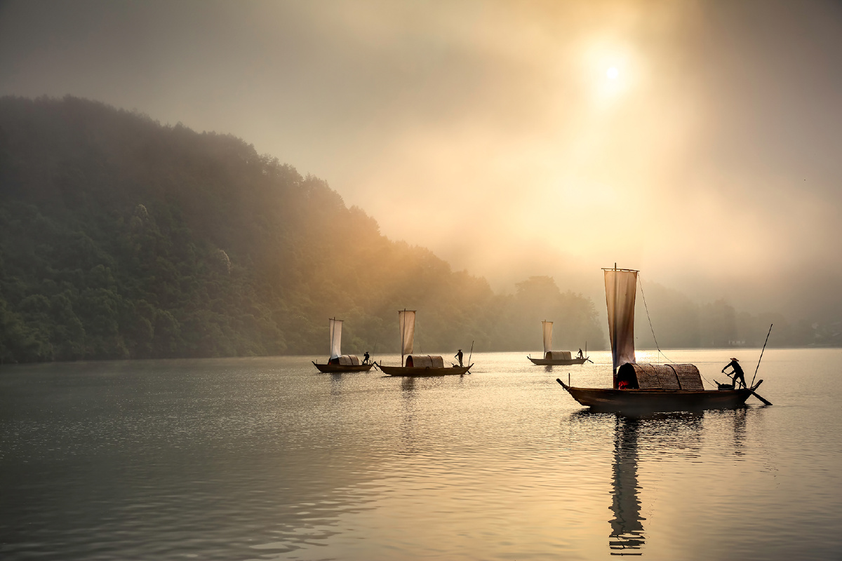 清晨,薄雾,金色的的阳光透过云层洒在瓯江上,帆影点点,波光