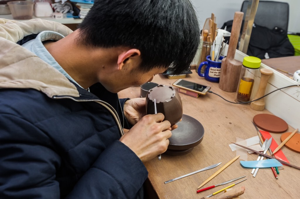 图片拍摄于2017年4月10日,云松堂工作室。做底。(尖刀、滴棒:以金属、竹木、塑料为材质制作,按制壶的用途修饰壶平面,转折打光和壶的局部、细部。)