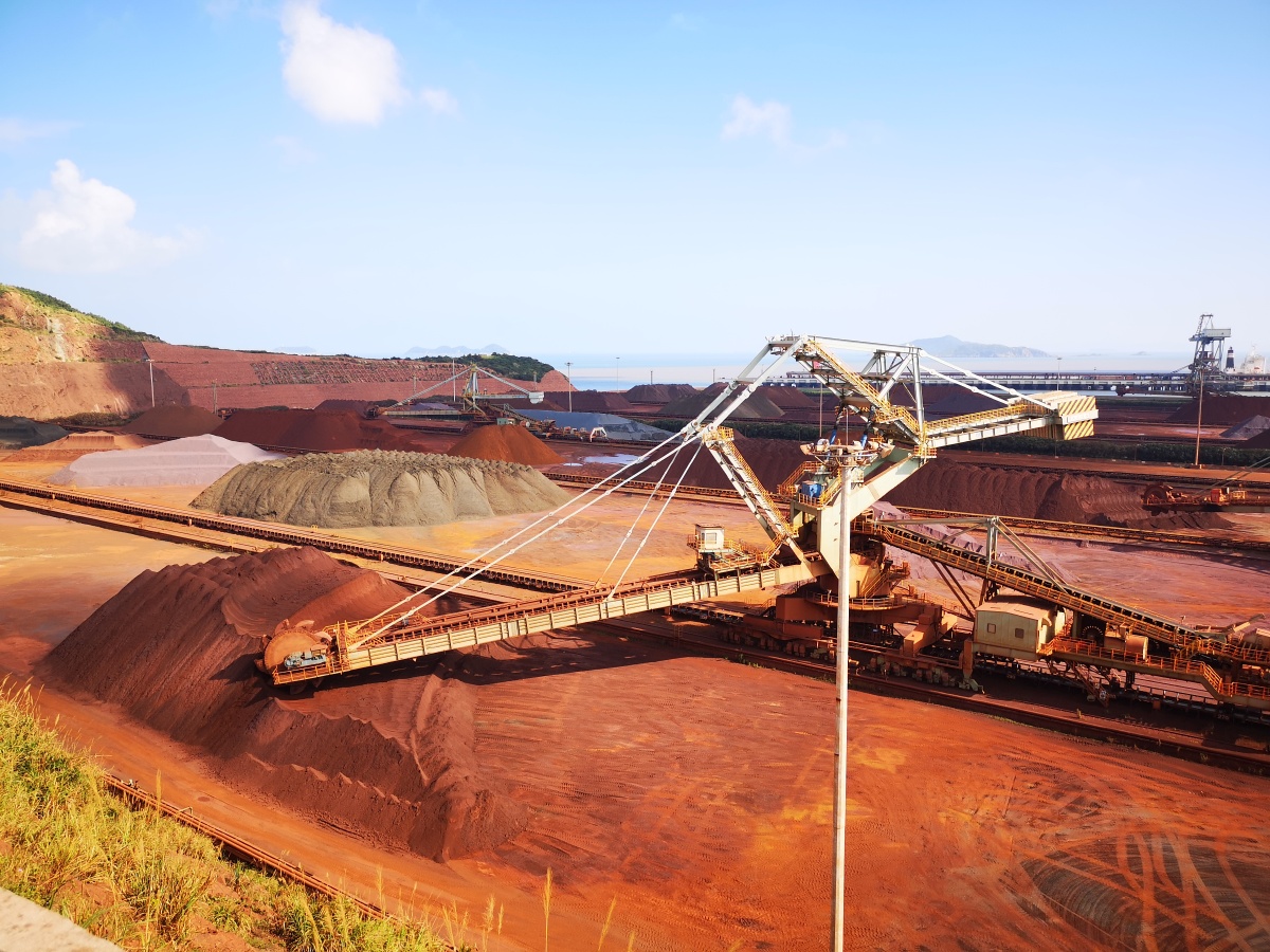 夏日下,港口边的铁矿厂依然轰鸣,一旁的山坡早已被染红.