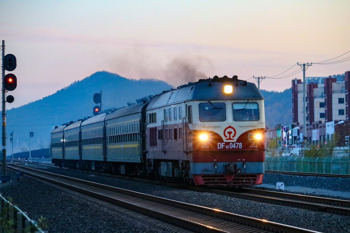 东风4d牵引绿皮小客行驶在薄暮下