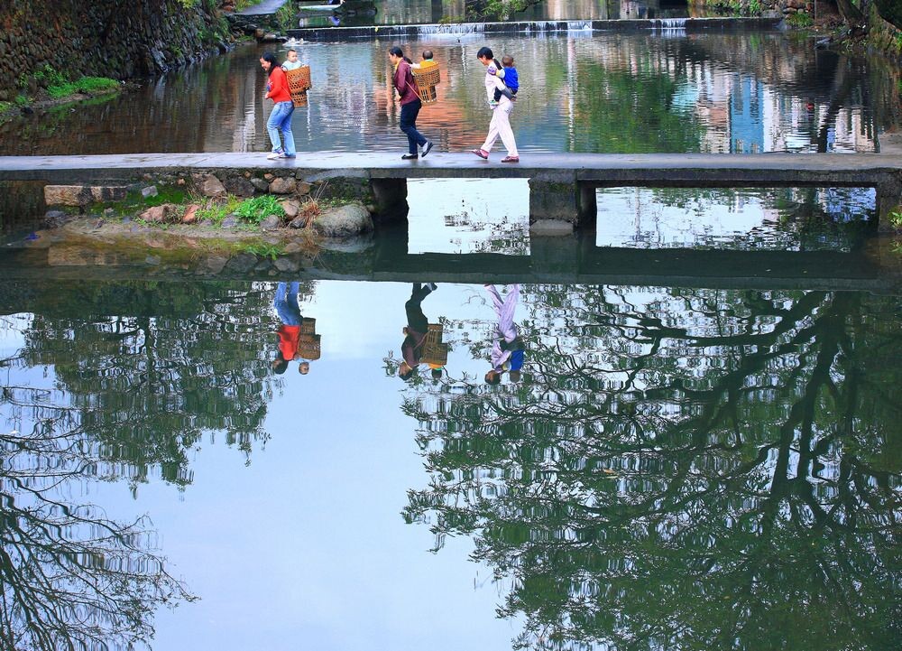 浙江宁海龙宫村，行人在石桥上行走的倒影