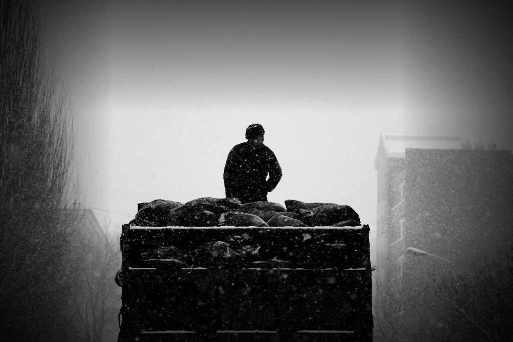 一个在我们学校运送垃圾的民工， 下雪天仍在工作。