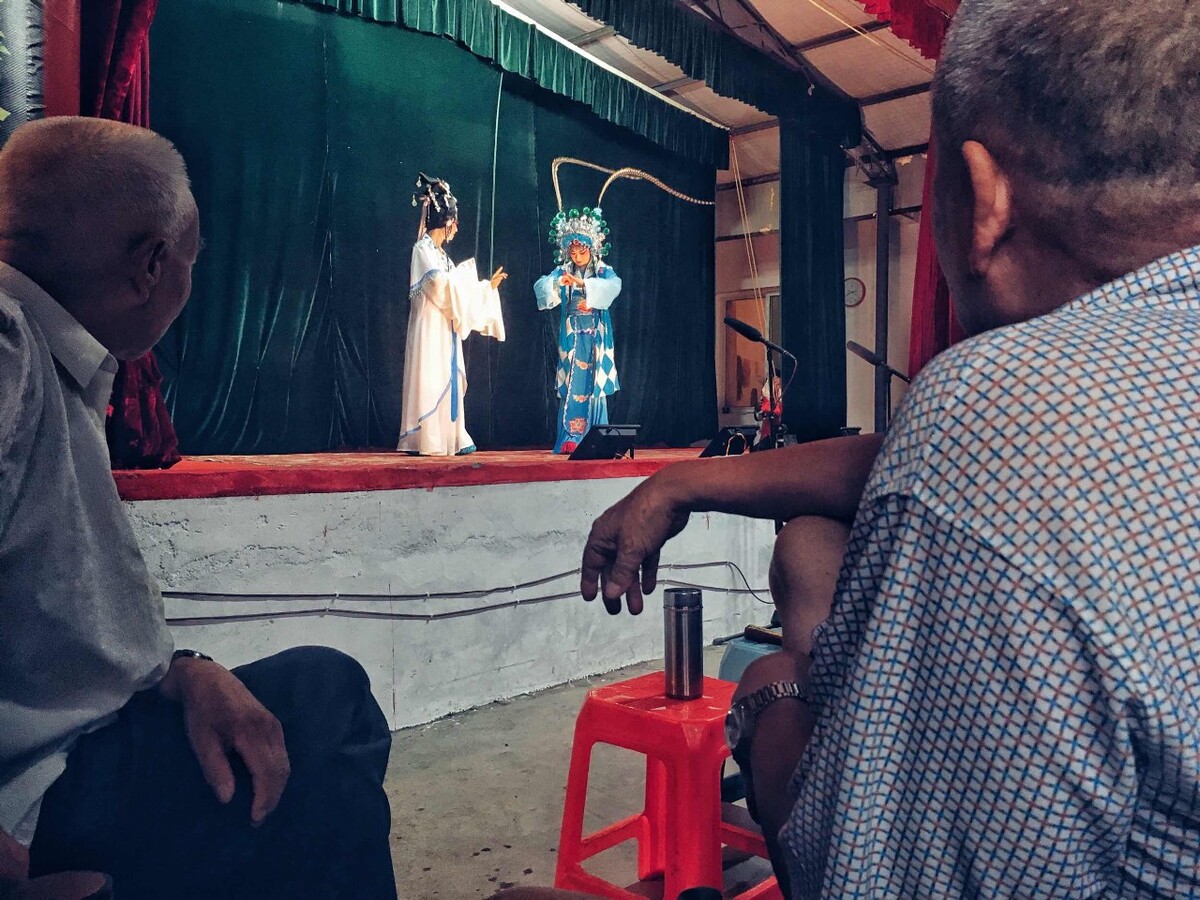 欣赏表演的观众们,时不时地要讨论一两句剧情