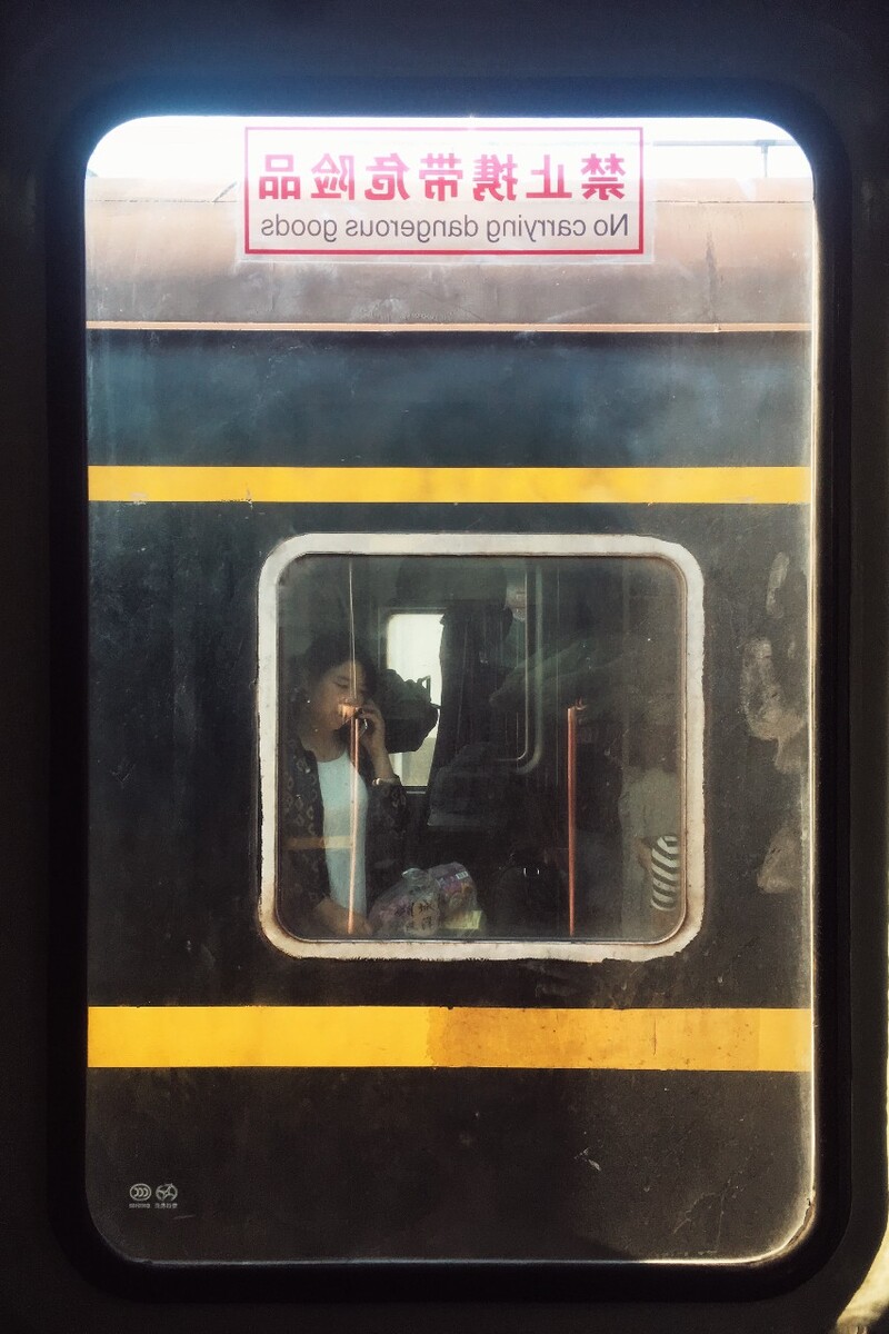 列车停靠中途小站，对面火车上的女人隔着车窗讲电话，我扫过她的脸，她的表情从容而恬淡。