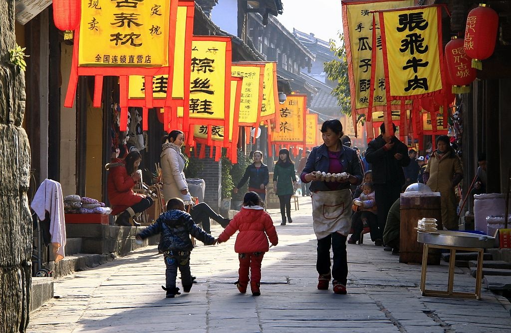 古老的街道,古老的房子,古代的旗风,古镇的韵味,一位餐厅服务员端着