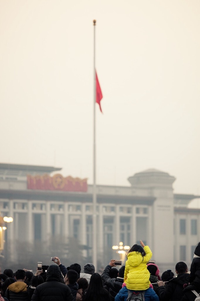 在一个中度污染的清晨，迎来了共和国2016年的首次升旗礼。新年第一天，五星红旗依旧在雾霾中徐徐升起，一个小学生骑在爸爸的肩膀上，情不自禁向国旗行礼致敬。