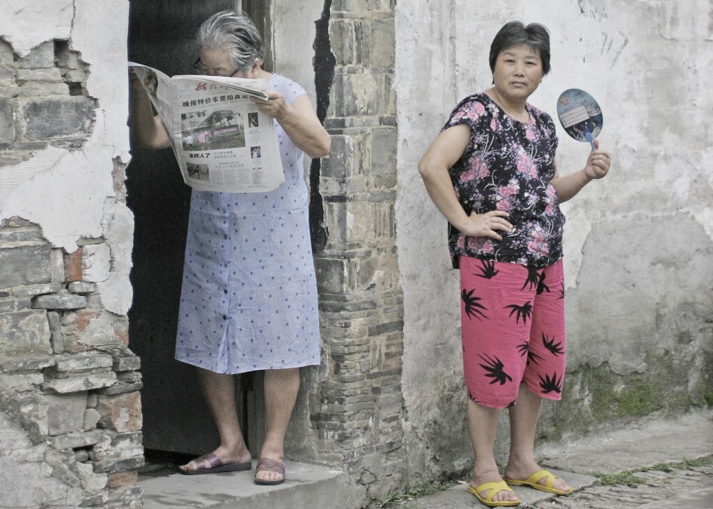 小巷里的居民傍晚喜欢出来乘风凉，站在门口看看报纸，“看看野眼”           2008年7五爱巷