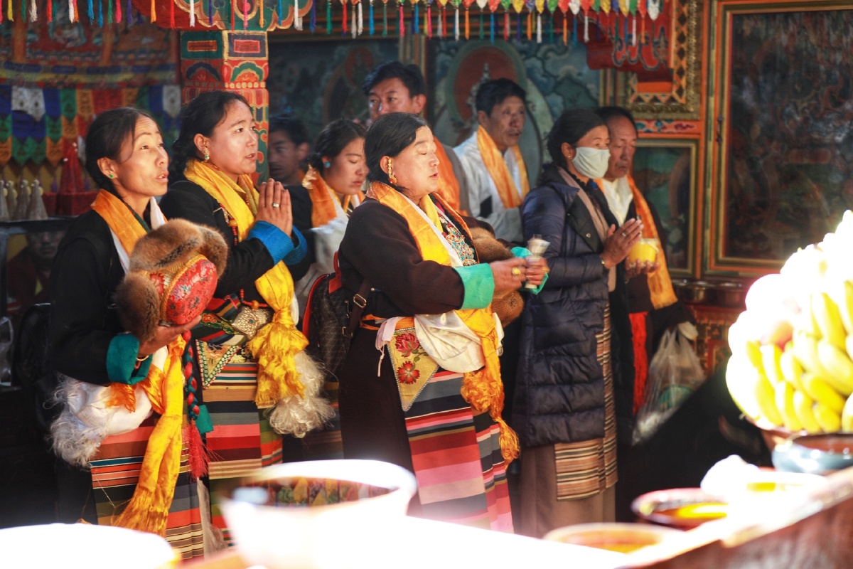 身着盛装纷纷焚香敬酒祈祷向女神敬献哈达并双手合十虔诚祈福