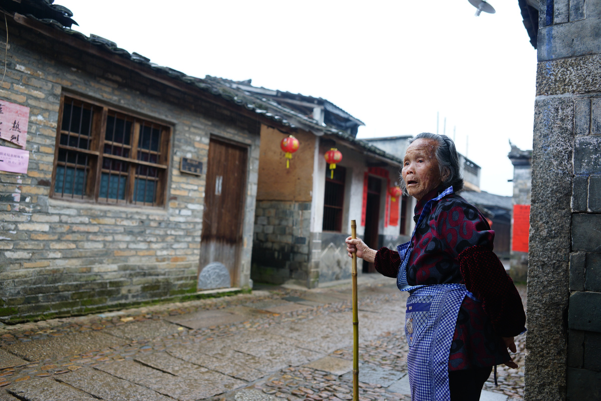 古村的街口,老奶奶拄杖远眺,似盼亲人归来.