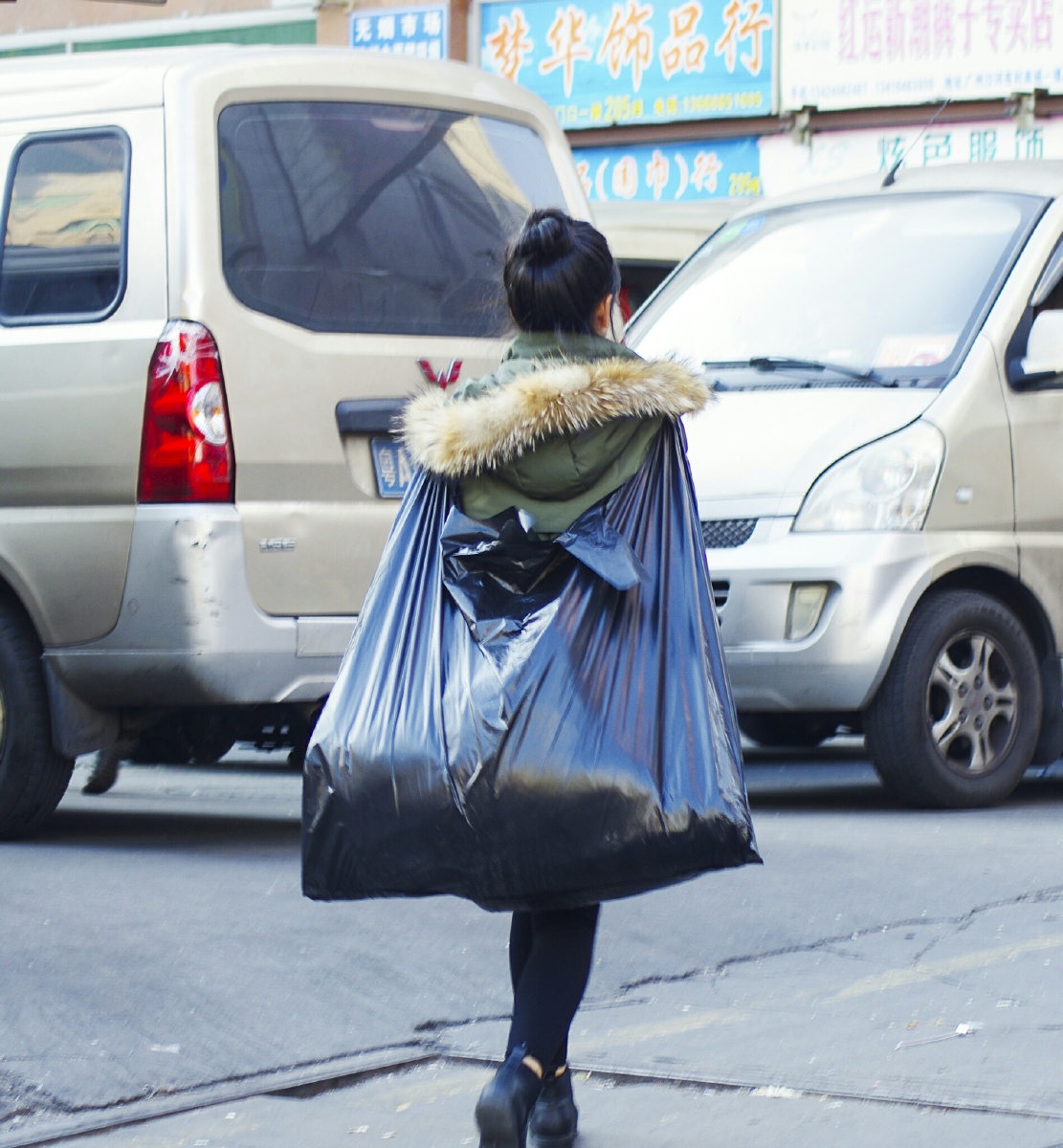 年轻姑娘将购物袋背在身后