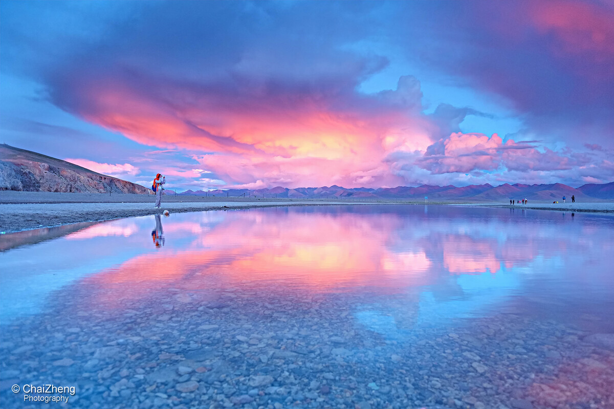 落日余晖<br />
站在纳木错湖边，仿佛置身于一个蓝色的世界。傍晚时分，远处落日的余晖渐渐洒在湖面上，蓝中透红，别样的风情