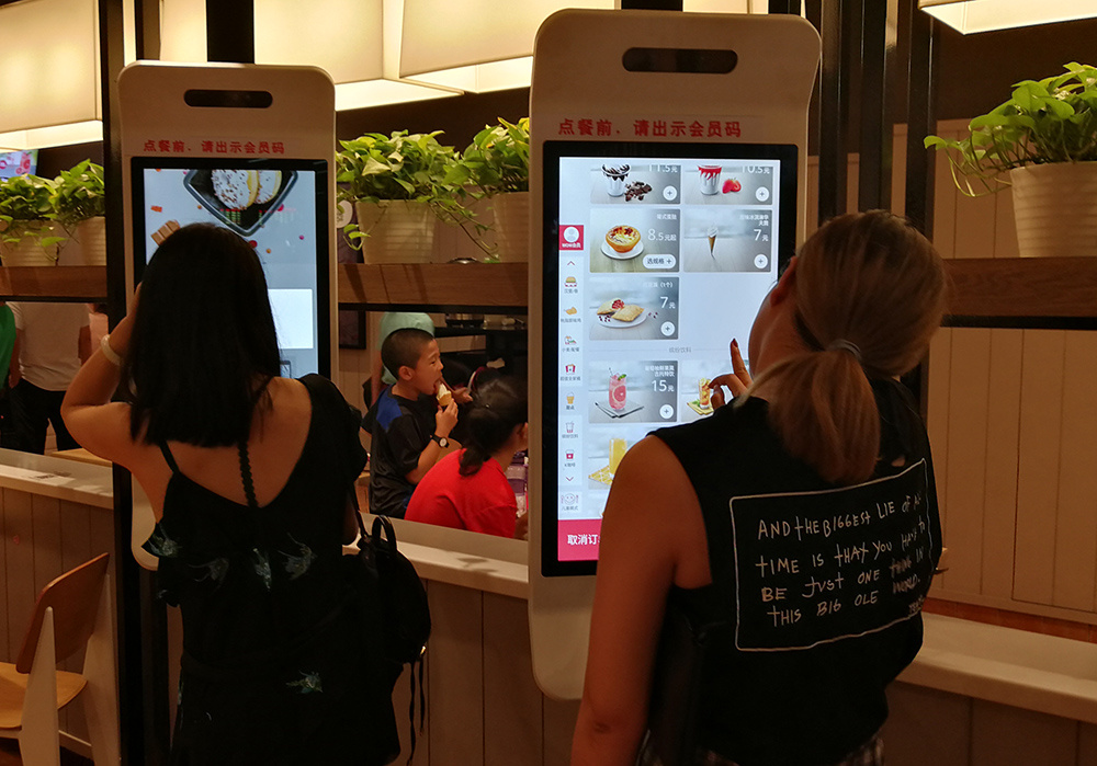 2018年8月12日摄于浙江省温州南站,乘客在用自助点餐机点餐.
