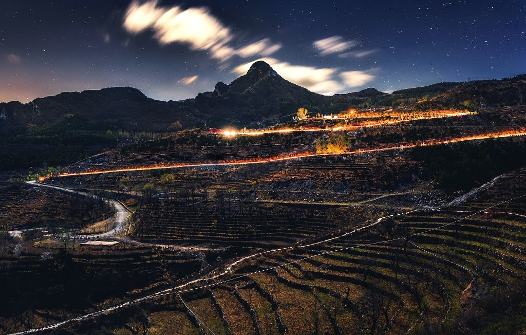 一个月明星稀的夜晚，我来到这北京最美梯田——大安山乡西苑村。春末的山风吹得恣睢，有着不亚于冬季的凉意。远处那个不知名的小山峰，形状好像有名的马特洪峰。刚好开过的汽车的车轨，好似接连的烽火，给平淡的夜色增添了一抹激情。