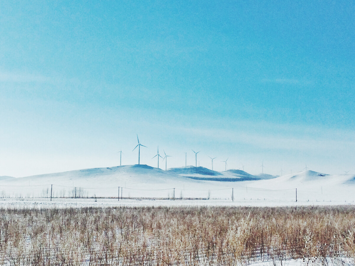 额尔古纳的暖冬，雪丘上的风车静静伫立。