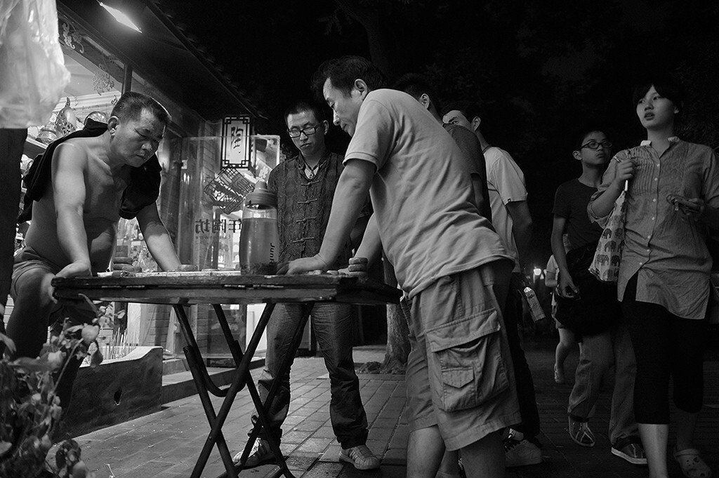 当街厮杀中的棋友，时代飞速前进，而他们，仍然还生活着老北京的韵味，仍然在老北京的韵味中生活。