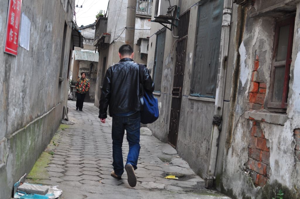 因为当地住宿条件不好，所以很多年轻的外来务工者都会在丽新工房租房子。这张照片是盲拍的，抓拍到一个年轻人和一个老人，新老交替，觉得很有意思。