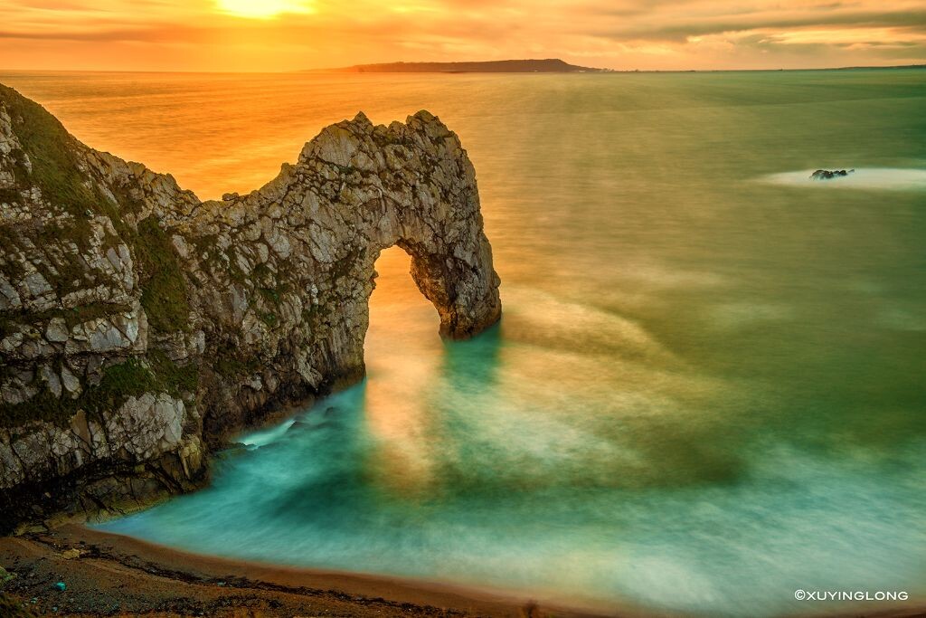 Durdle door<br />
第一次来到被无数人拍的#Durdle door#，零度的海风吹的人站都站不稳，阴郁的阳光若隐若现，实在难以表现，最后用了10档ND拍下这张。嵌在晶莹剔透海面上的象鼻山。。  最后，大家圣诞节快乐~