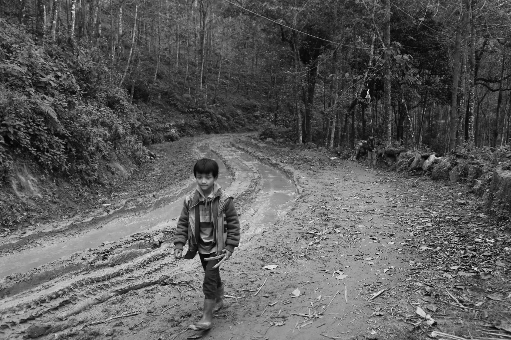 走在回家路上,手里拿着在山里找到的树丫杈,准备回家做弹弓。2014.11.16云南元阳县