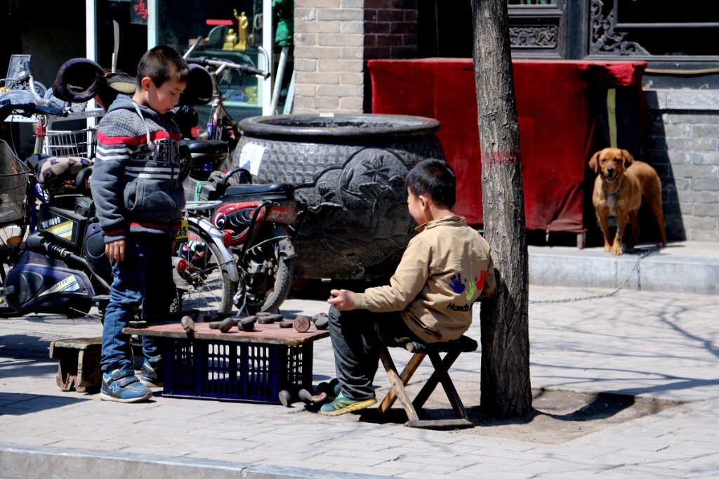 街旁两小儿对弈，一招不爽，怒而踢翻棋盘。