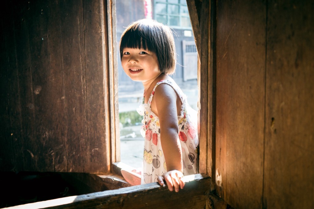 暑假去农村 我在堂屋里修图 有小孩就很好奇又很小心的来在门外探头看我在做什么 发现我也不是什么吃人的怪物以后 又索索得跑出去玩 还想叫我也一起 那时候就抓到了这张毫不胆怯的愉快的笑脸 