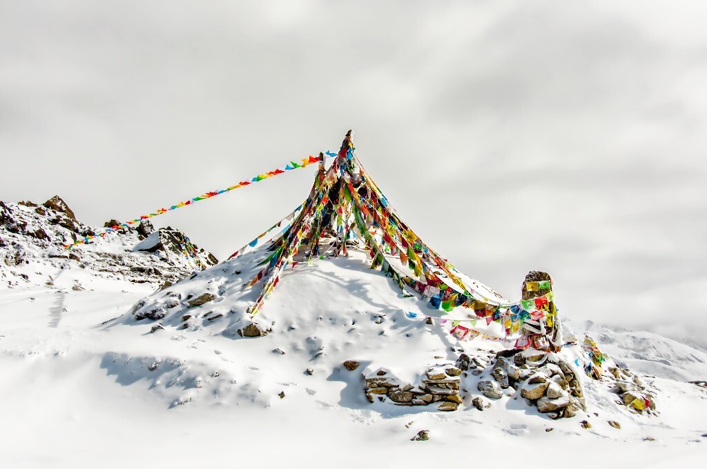 无人的雪山，经幡在风中拂动。