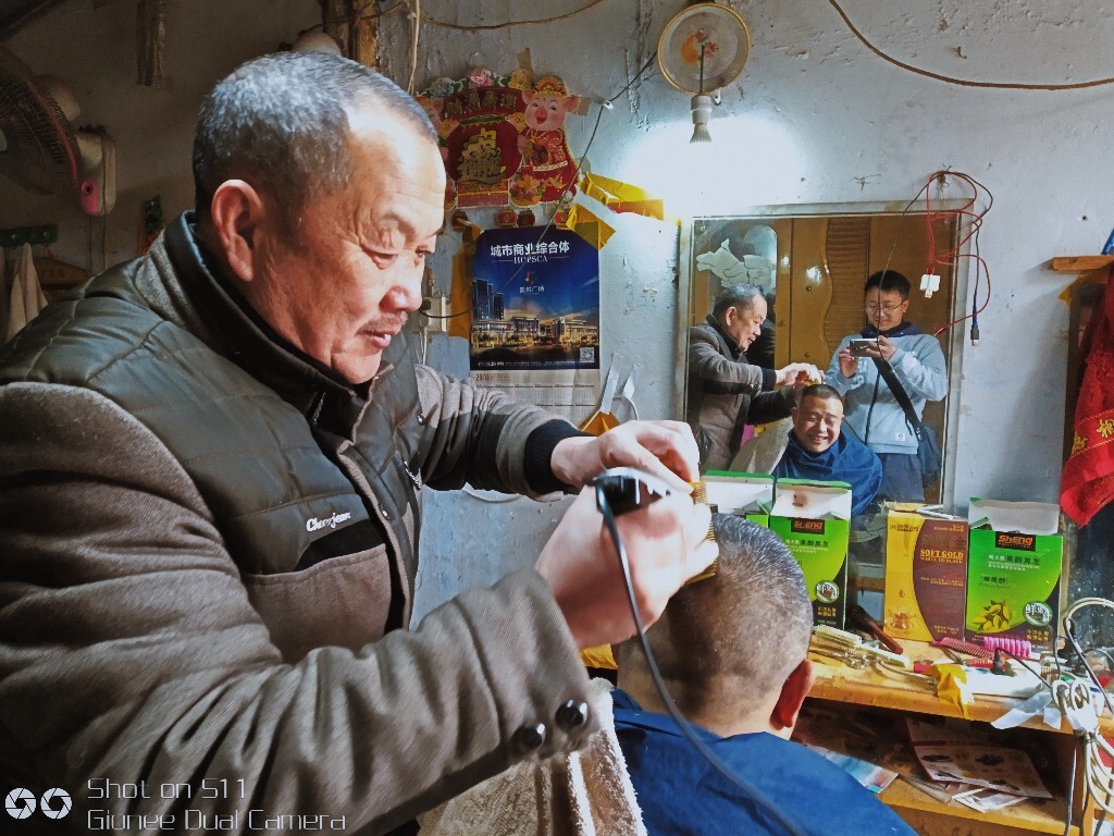 和理发师傅交谈的我。