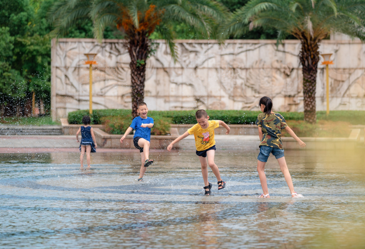 街拍戏水童年午后一场暴雨广场的积水成了孩子们的天
